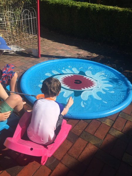 Kids lounging in chairs around Jasonwell Splash pad sprinkler play mat