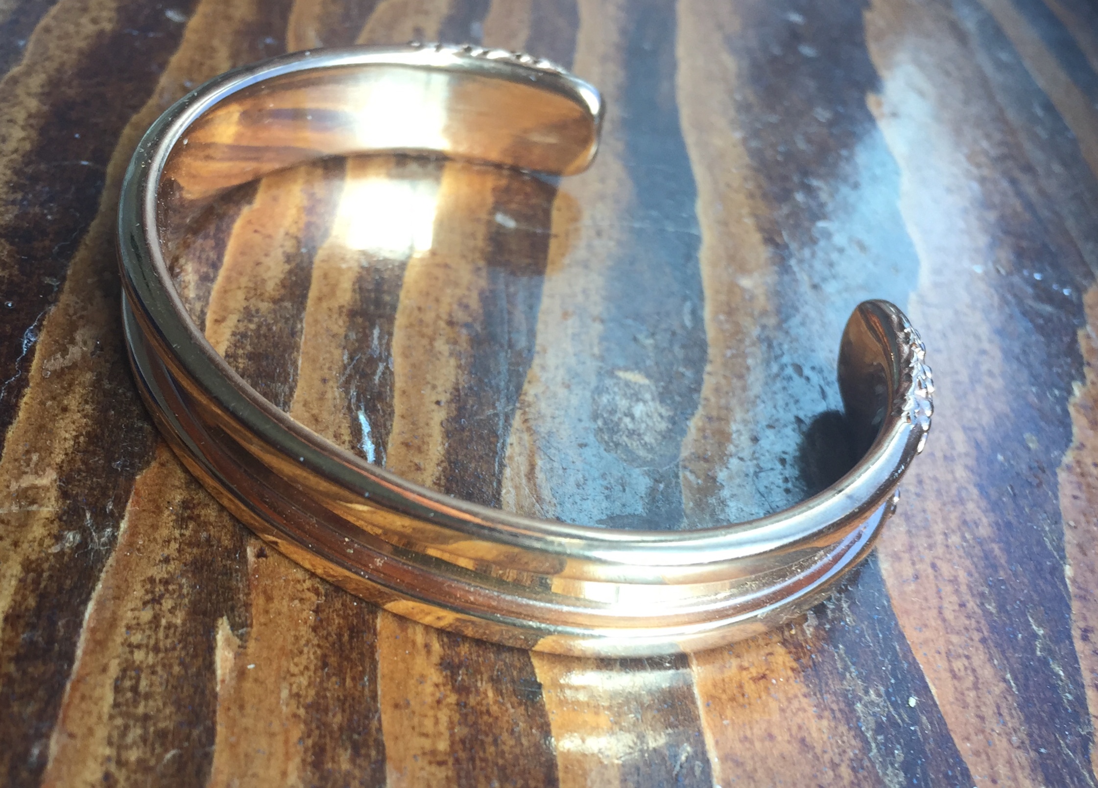 Empty hair tie elastic bracelet in rose gold on wood grain surface