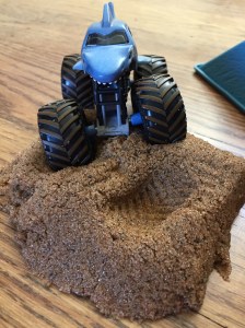 Monster Truck Jam Kinetic Sand Starter Set blue shark truck driving over dirt sand pile