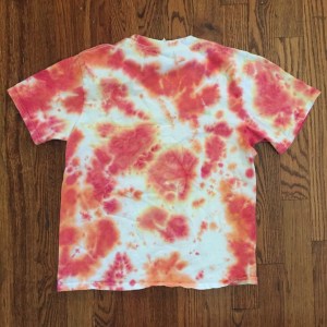 Child's white t-shirt tie dyed with orange red and yellow