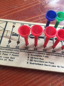 Close up of wooden football peg game with red blue and green pegs in board