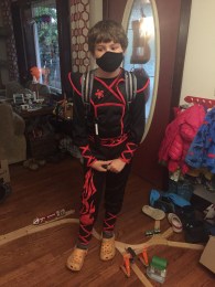 Child dressed up in ninja costume with black face mask