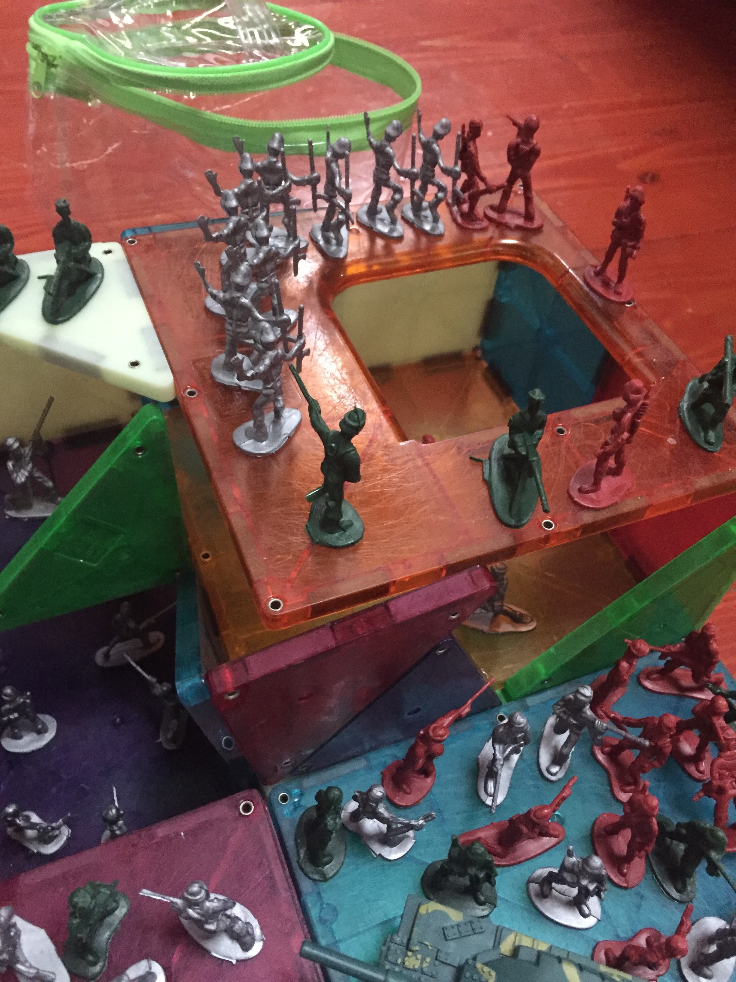 Toy soldiers army men toys set up around Magna-Tiles building