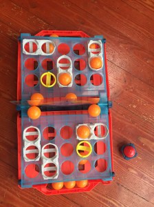 Battleship shots game set up with orange balls and red ball on side
