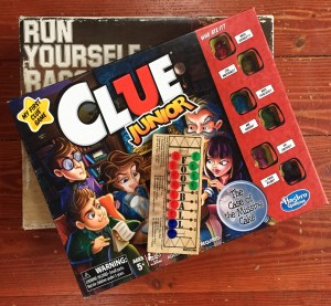 Run Yourself Ragged obstacle marble game, Clue Junior, and Football peg game in stack on hardwood floor