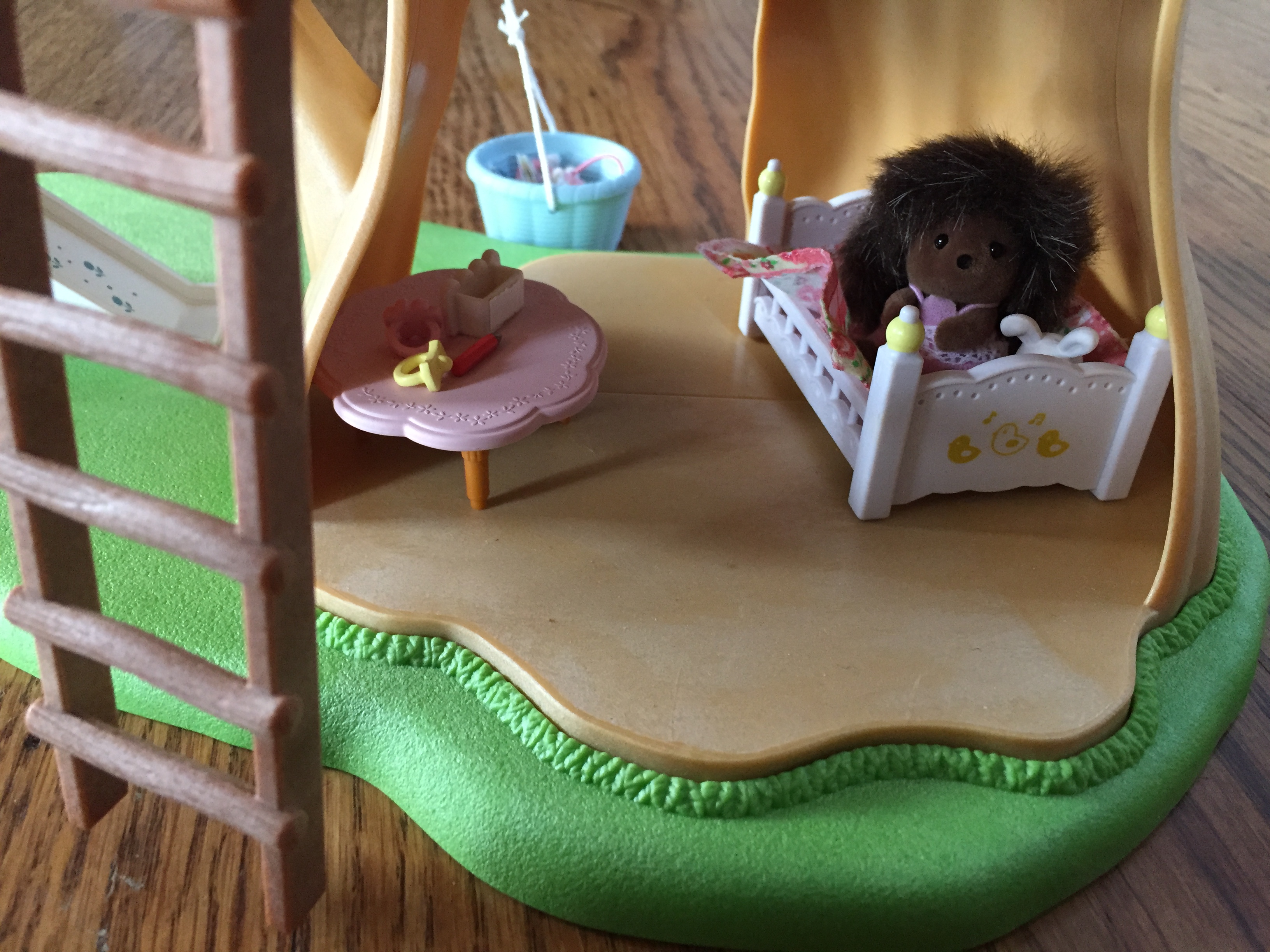 Calico Critter Adventure Treehouse bottom room tucked inside tree trunk furnished with bed table and baby hedgehog