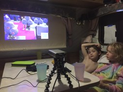 Asus Zenbeam E1 pocket projector projecting Animal Crossing Nintendo Switch game onto closed blinds