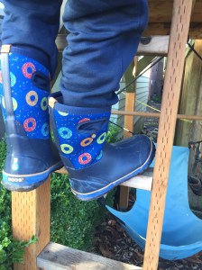 Child climbing ladder while wearing Bogs big kid boots size five donut pattern on blue background