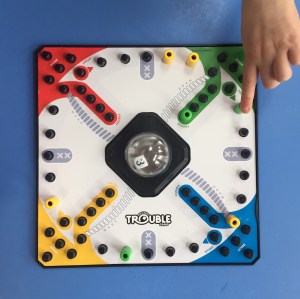 Child moving piece on Trouble board game