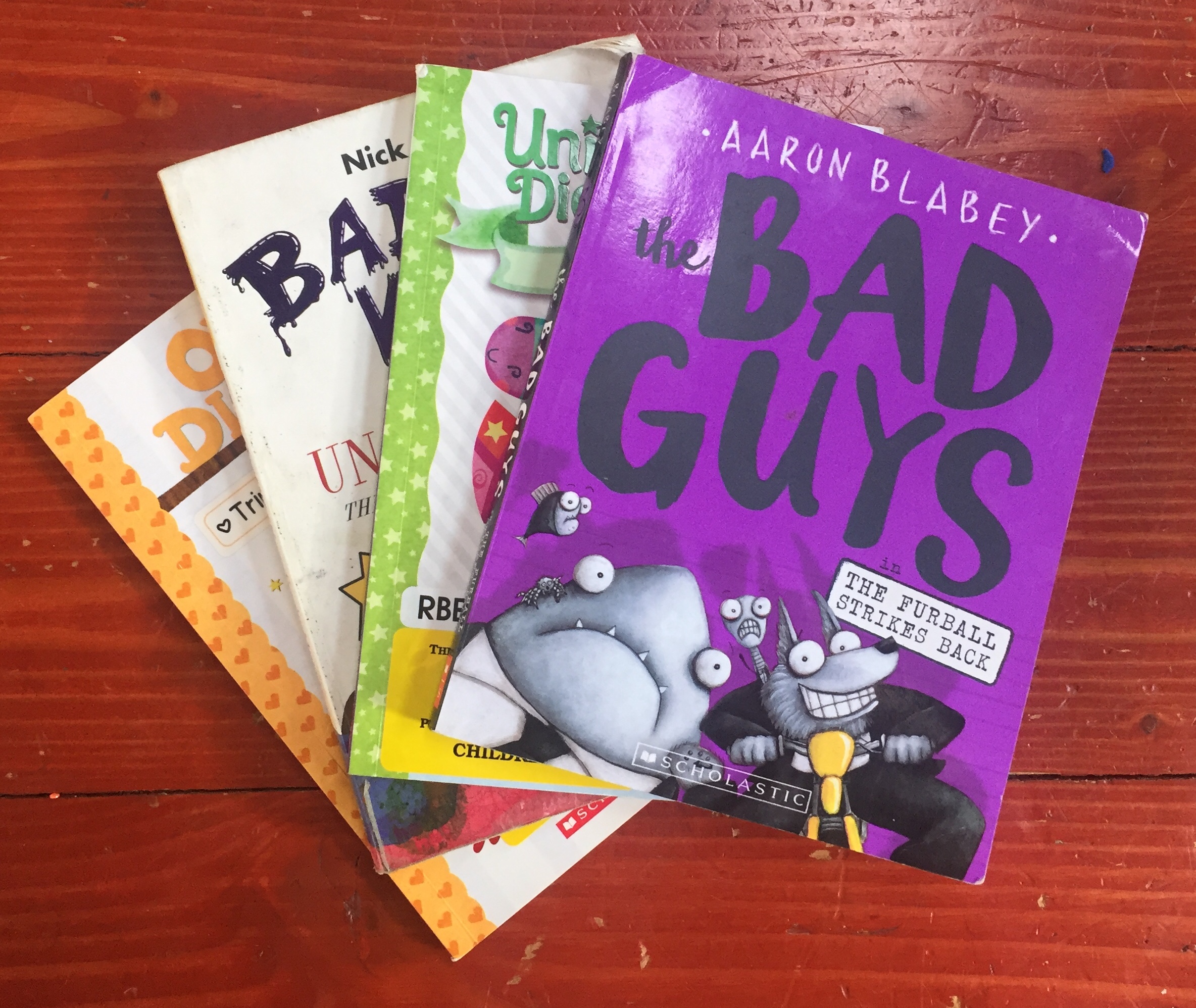 Graphic novels for young readers Bad Guys Unicorn Diaries Bad Kitty Owl Diaries in a fanned stack