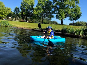Six year old padding on lake shore in Lifetime Wave Youth Kayak