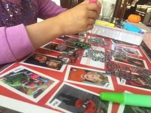 Nine year old child squeezing window paint pen from Made By Me Create Your Own Window Art suncatcher project kit