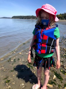 Child wearing life jacket on beach