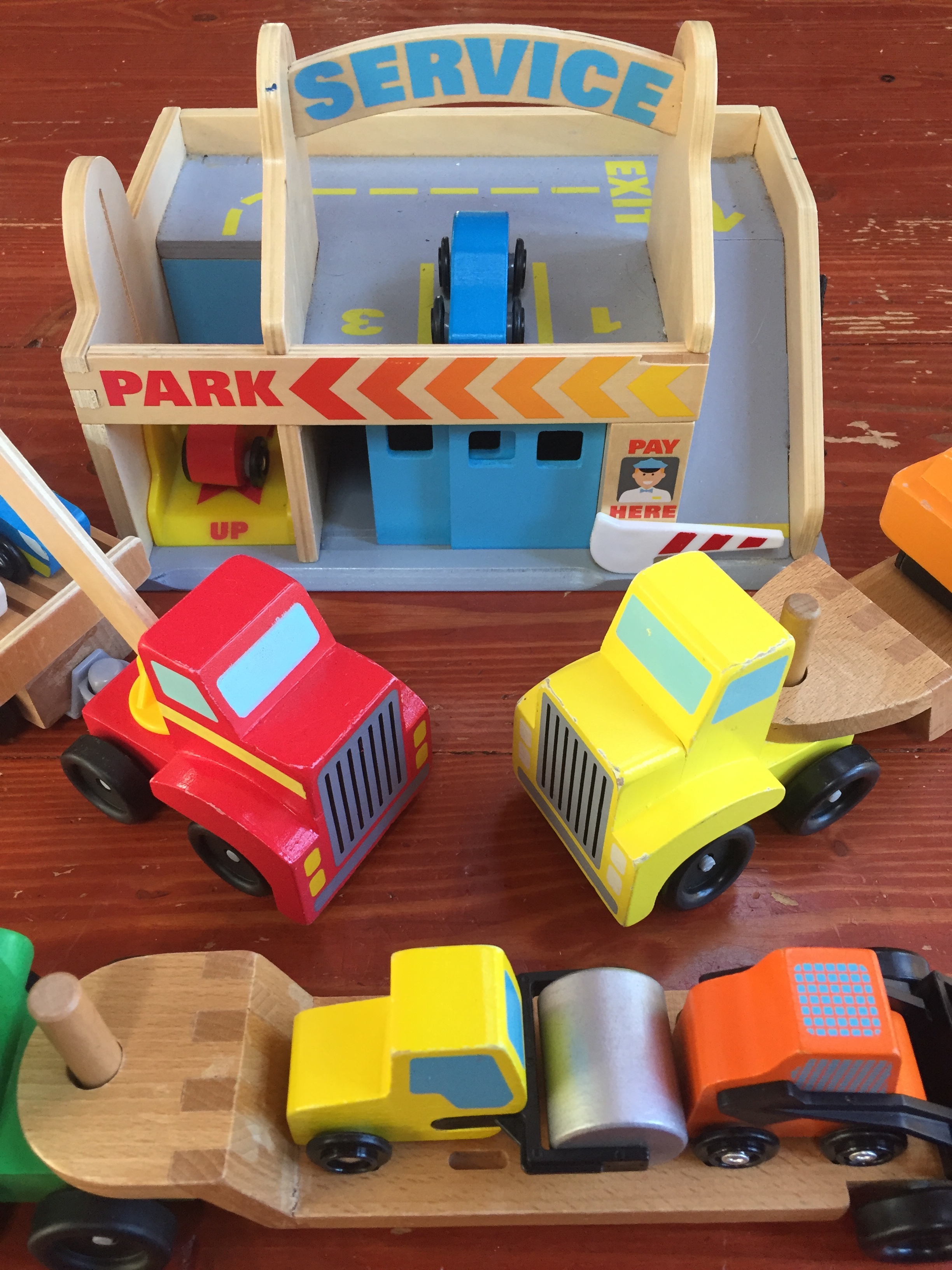 wooden vehicle toys Service Station Garage Play set from Melissa & Doug Skid steer and steam roller on flatbed and other transport trucks