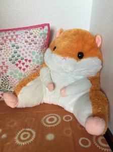 Hamster backrest lumbar support pillow in orange and white on child's bed
