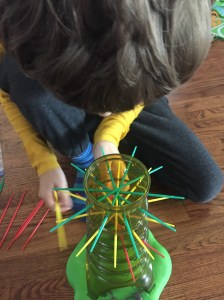 Kerplunk sloth version kids game child placing sticks in clear cylinder tree