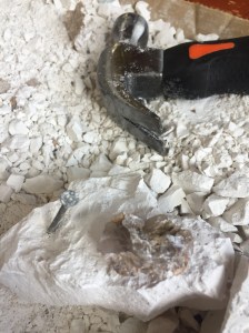 Excavation kit for kids small amount of plaster left with fossil rock sitting on top and hammer and nail in background