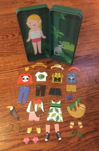 Petit Collage magnetic dress up tin Nature Studies theme with magnet pieces laid out 