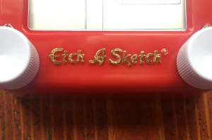 Etch A Sketch logo on Pocket version of toy gold letters on red background