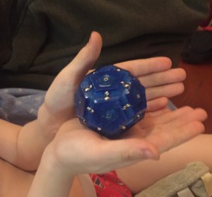 Child holding Speks Geode cobalt blue sphere magnetic fidget toy in hands