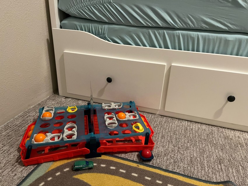 IKEA Hemnes Daybed, twin mattresses stacked on top, Battleship Shots game set up on carpet