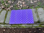 Folding foam seat pad camping outdoor kids insulated weatherproof foam mat in purple on stone wall