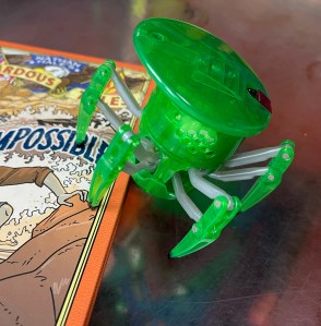 HEXBUG Spider in green crawling on top of book