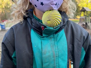 Child holding yellow Waboba Spizzy Ball under chin