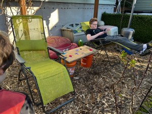 Parent lounge set up in backyard with lounge chairs and snack table