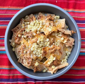 Nachos with browned tortilla chips in round cake pan after heating