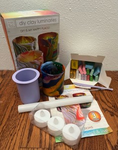 DIY Clay Luminary Kit with pieces for craft project and completed tea light candle holder laid out