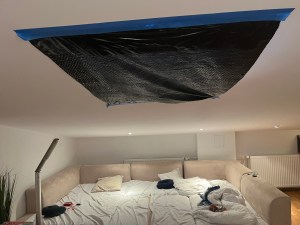 Black garbage trash bag taped to ceiling to block light from skylight