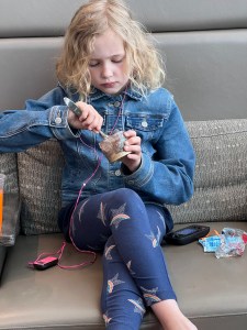 Nine year old girl eating snack while listening to MP