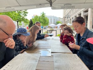 Adult at outdoor restaurant table mixing up Mobius Sphere ball fidget toy puzzle