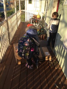 Child on porch wearing Crckt kids' backpack with unicorn print