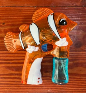 Orange clownfish shaped bubble gun blower toy for kids with bubble container attached