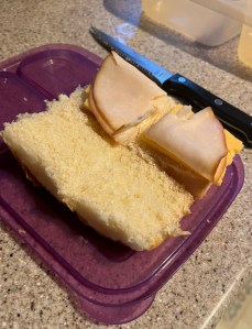 Two King's Hawaiian Rolls sliced in half to make ham and cheese slider sandwiches for kids' lunchbox