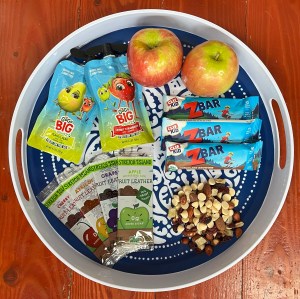 Snack platter for kids with apples, big fruit pouches, fruit leather strips, Clif Z Bars, and snack mix