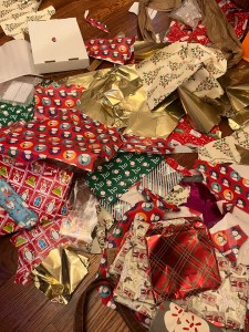 Christmas wrapping paper torn in pile on floor