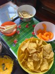 Electric football game field with snacks of chips, cheese dip, apple slices, and cheese curls