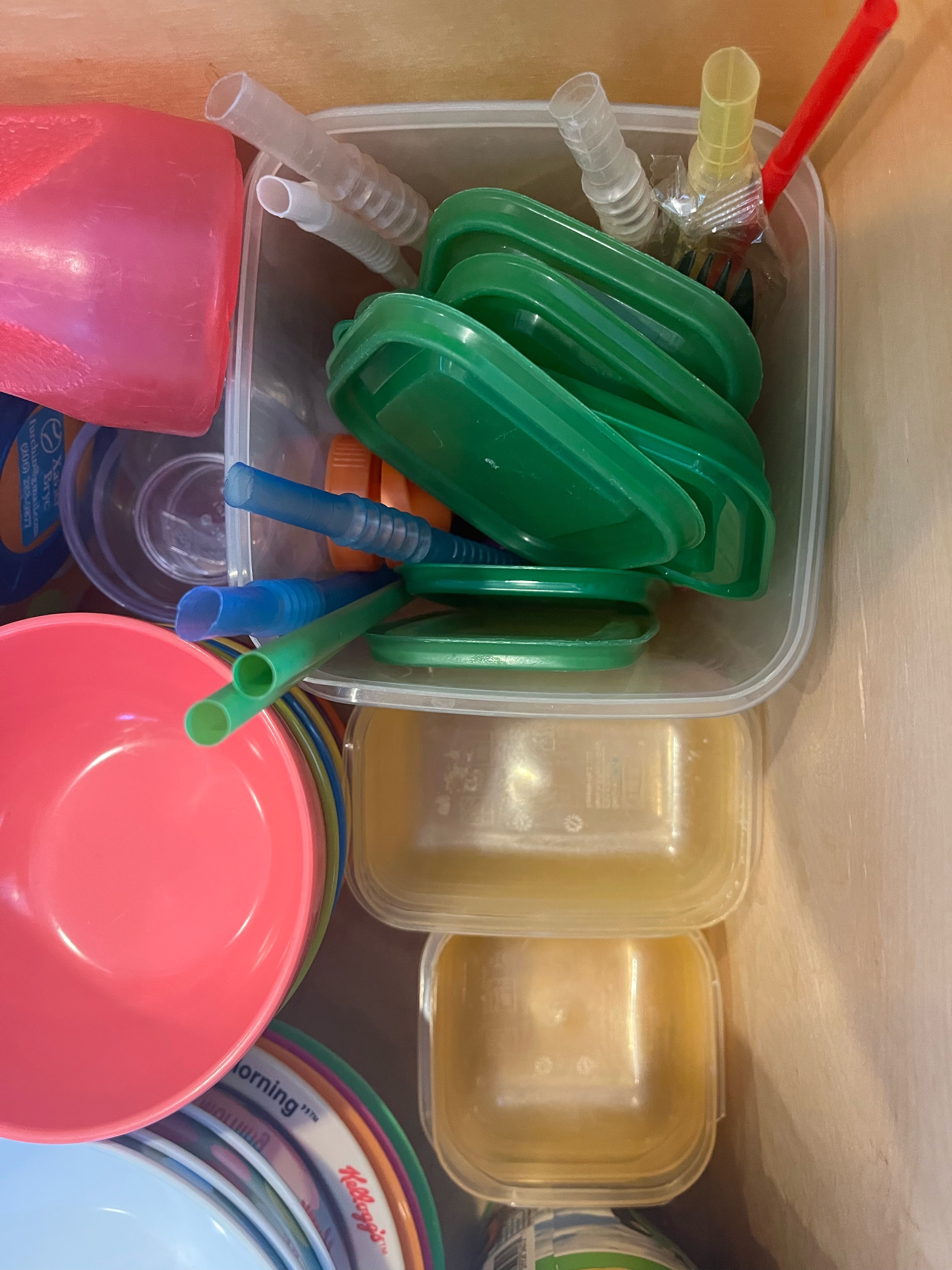 Kitchen drawer filled with IKEA Pruta food containers and lids with other brightly colored dishes