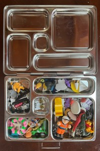 Bento box lunch box holding tiny kids toys and pieces