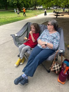 Grandmother and grandchild using double camp couch loveseat at the park
