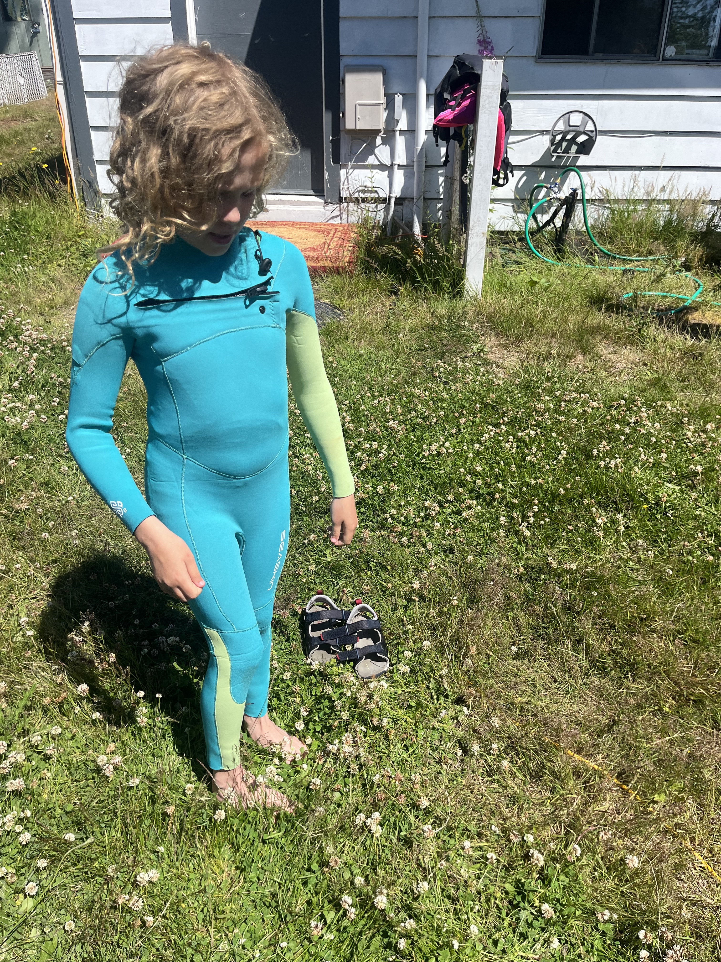 SeaSkin Kids Wetsuit in turquoise on eleven year old girl standing in grass