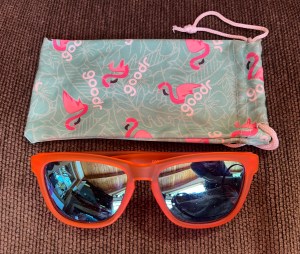 Goodr sunglasses orange Donkey Goggles style with turquoise bag printed with pink flamingos