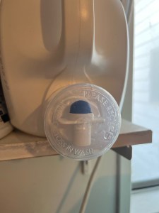 Liquid laundry detergent cap lid with Toss in Wash printed on bottom