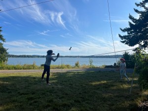 Kids playing Waboba Voli paddle game by water