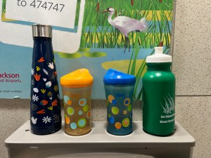 Water bottles lined up on water fountain bottle refill station at airport