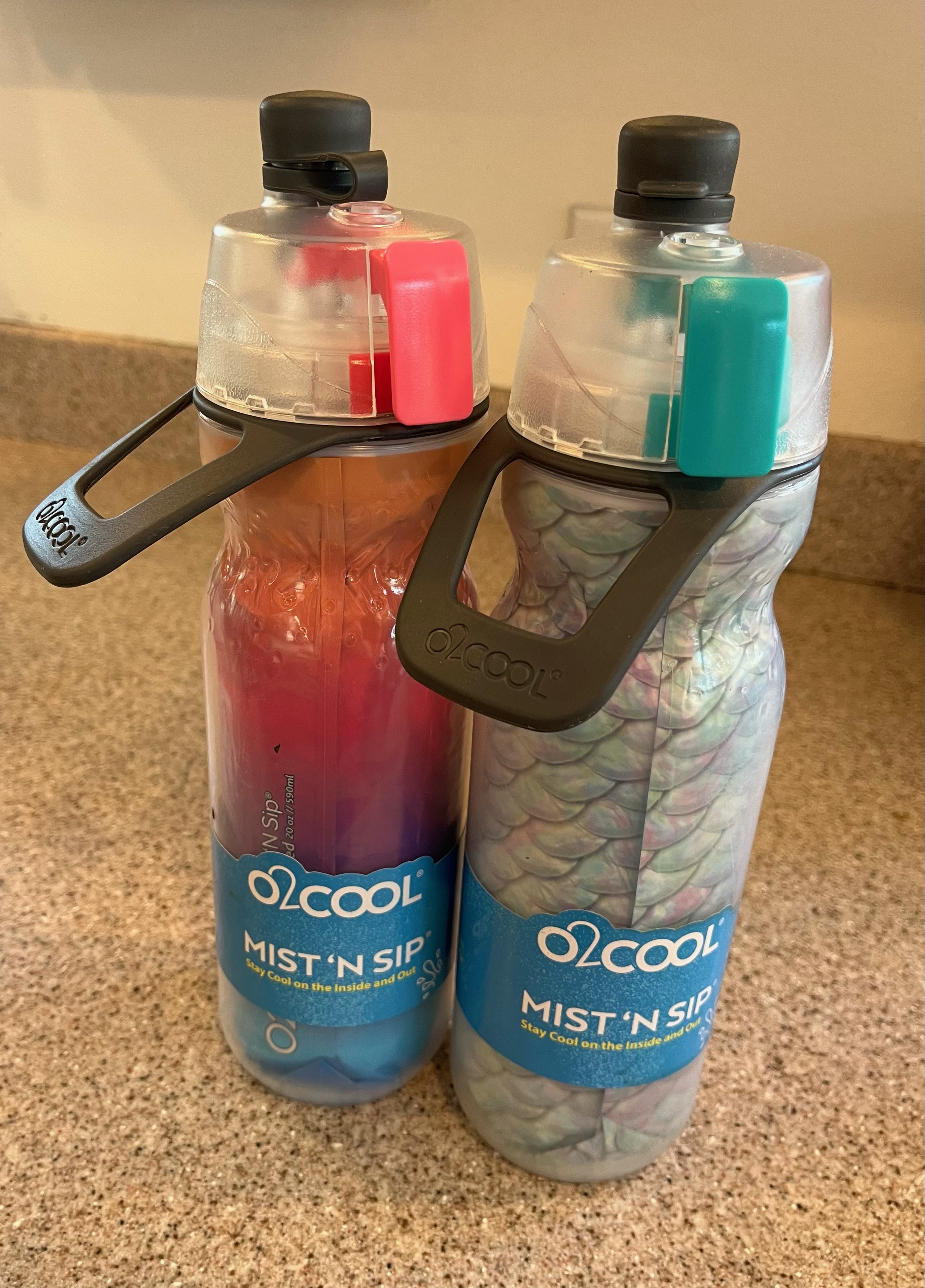 O2Cool water bottles in mermaid scale and bright pink rainbow colors with covered spout and misting feature