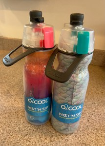 O2Cool water bottles in mermaid scale and bright pink rainbow colors with covered spout and misting feature